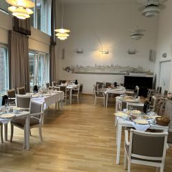 Ein eleganter Speisesaal mit gedeckten Tischen lädt zum Frühstück im gemütlichen Ambiente ein.