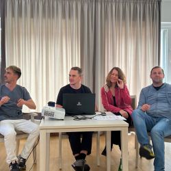 Vortrag einer Gruppe am Tisch mit Beamer