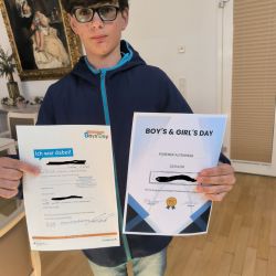 Ein Junge hält stolz seine Urkunden vom Boys' Day und einem Altenheim in der Hand. | © Name
