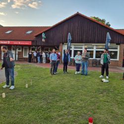 Eine Gruppe von Menschen spielt im Freien vor einem Restaurant in der Region Herz. | © Name