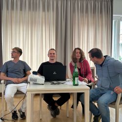 Vortrag einer Gruppe am Tisch mit Beamer