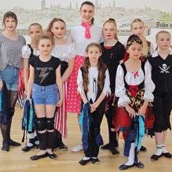 Eine Gruppe junger Tänzerinnen in bunten Kostümen posiert lächelnd nach einem Aerobic-Auftritt im Altenheim im Mai 2025.