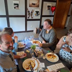 Freunde genießen ein gemeinsames Essen im Restaurant, umgeben von festlicher Dekoration und gemütlicher Atmosphäre.