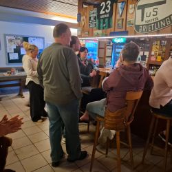 Menschen in einer Bar, die sich unterhalten und Getränke genießen, während die Atmosphäre gemütlich ist. | © Name