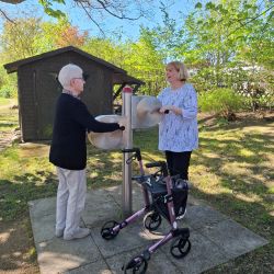 Zwei Frauen nutzen im Freien ein Spielgerät und genießen den sonnigen Tag im Park. | © Name